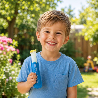 Kind hält HERBY Family Elektrolyte-Eis in blauer Eishülle im Garten